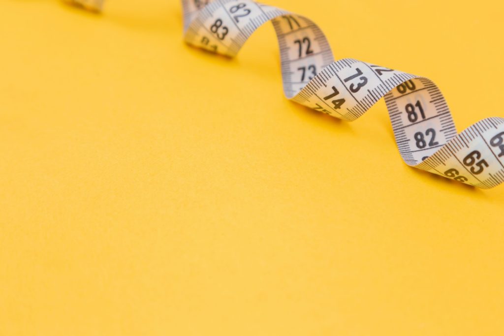 white tape measure on yellow surface